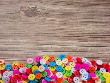 Boya ya da el yapımı konsept için ahşap masadaki çok renkli düğmeler.