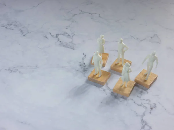 The plastic  figure business man on whit marble for teamwork concep