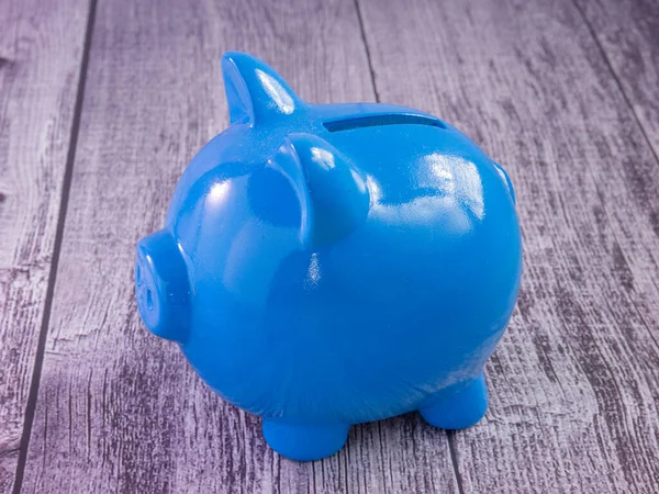 The blue piggy bank on wood table for business concept