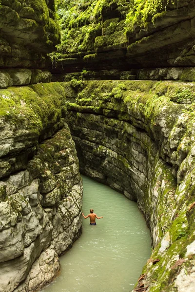 The man goes on a deep canyon in the jungle of Abkhazia — Stock Photo, Image