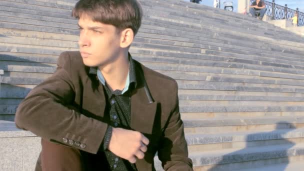 Joven hombre de negocios sentado en las escaleras . — Vídeo de stock