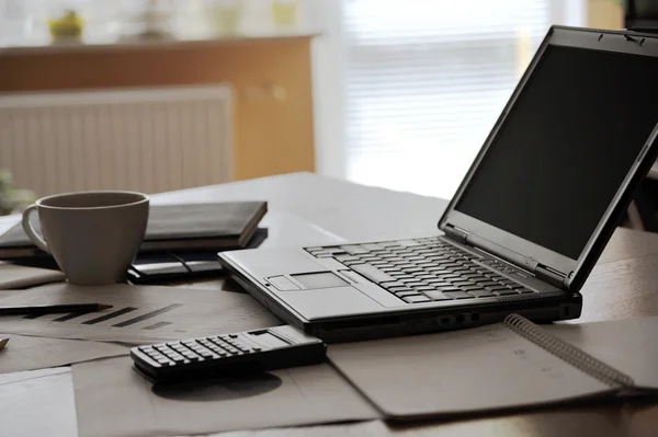 Рабочее место с открытым ноутбуком с черным экраном и бизнес-документами Стоковое Фото