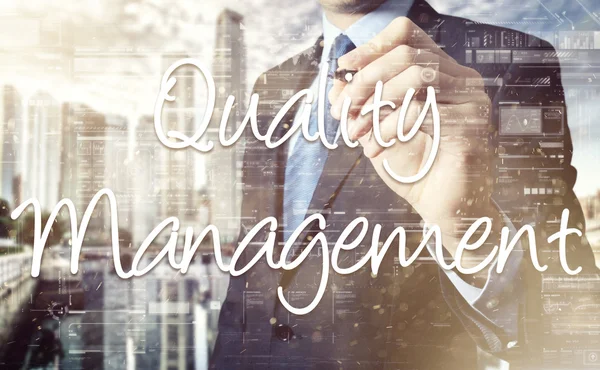 Бизнесмен пишет Quality Management на прозрачной доске — стоковое фото
