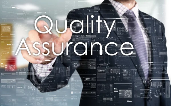 Бизнесмен выбирает Quality Assurance с сенсорного экрана — стоковое фото