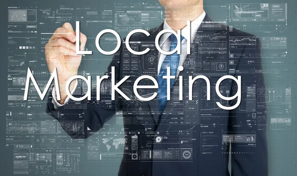 L'uomo d'affari sta scrivendo Local Marketing nel consiglio trasparente — Foto Stock