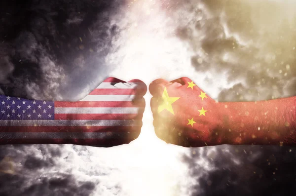 Deux poings se frappant au-dessus du ciel sombre, conflit entre les États-Unis et la Chine — Photo