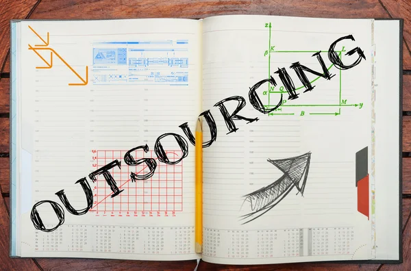 Notebook with text inside Outsourcing on table — Stock Photo, Image