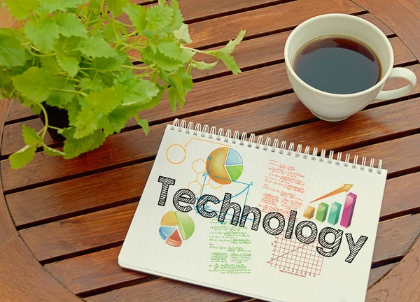 Notebook with text inside Technology on table with coffee and plant — Stock Photo, Image