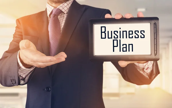 Homme d'affaires montrant concept d'entreprise sur tablette debout dans le bureau : Business Plan — Photo