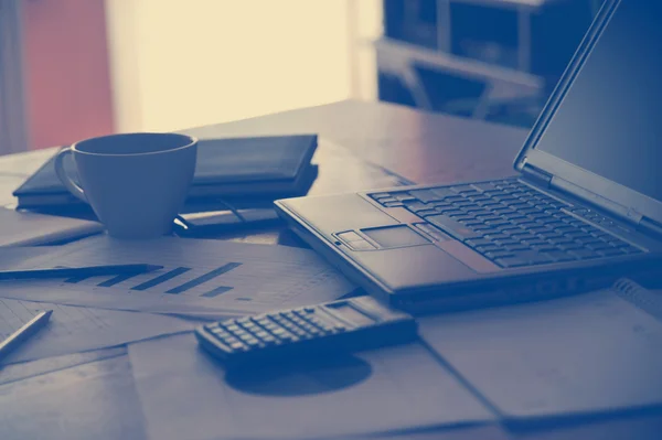 Arbeitsplatz mit offenem Laptop mit schwarzem Bildschirm und Geschäftsdokumenten — Stockfoto