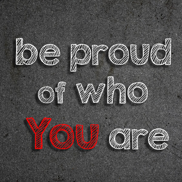 "Be proud of who you are" written on a chalkboard