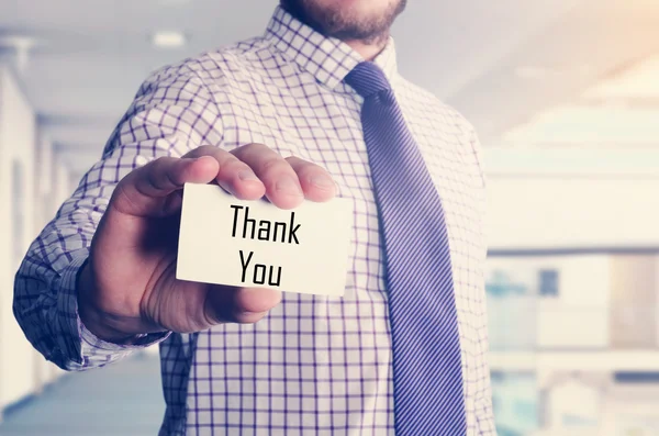 Geschäftsmann im Büro zeigt Karte mit Text: Danke — Stockfoto