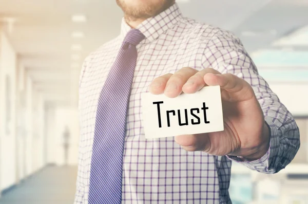 Businessman in office showing card with text: Trust — Stock Photo, Image