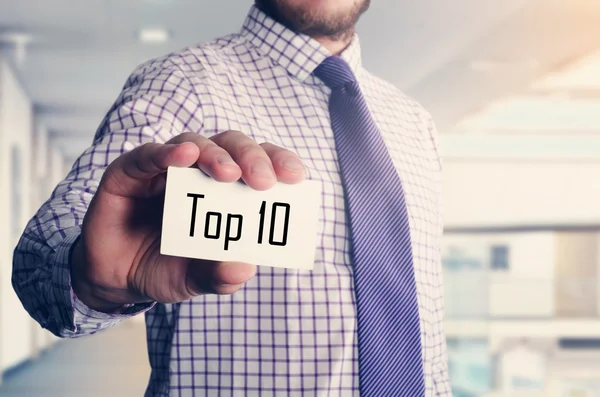 Hombre de negocios en la oficina que muestra la tarjeta con el texto: Top 10 —  Fotos de Stock