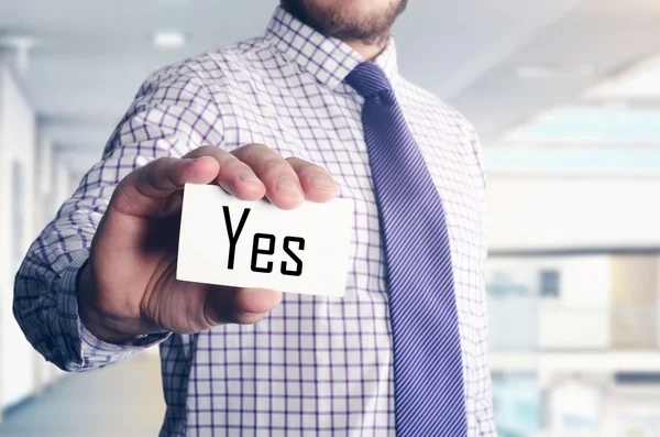 Geschäftsmann im Büro zeigt Karte mit Text: ja — Stockfoto