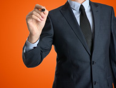 Genç işadamı bir şey turuncu zemin üzerine yazma