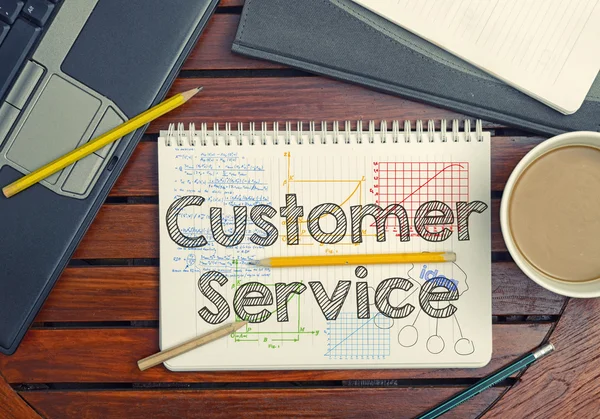 Notebook with text inside Customer Service on table