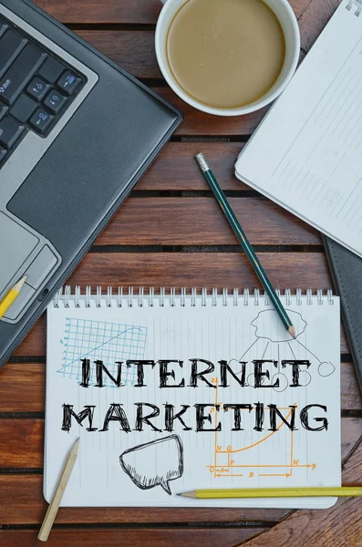 Notitieboekje met tekst in Internet Marketing op tafel met koffie — Stockfoto