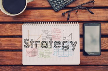 Kahve, cep telefonu ile tabloda strateji içindeki metin ile defter