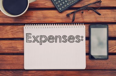 Notebook, cep telefonu ve hesap makinesi kahve masada içinde metin giderleri ile