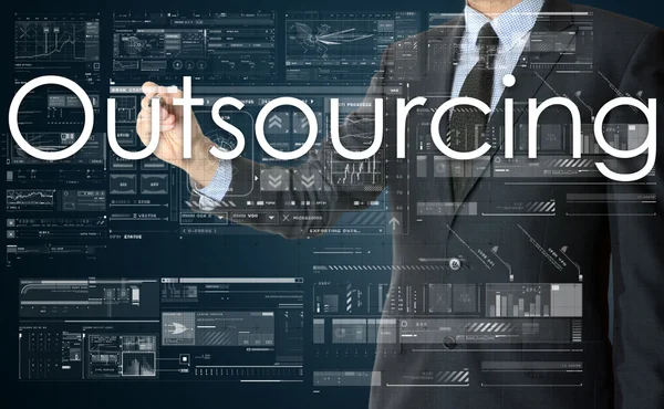 O empresário está escrevendo Outsourcing no quadro transparente — Fotografia de Stock