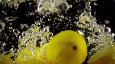 Ultra Slowmotion suda içine sıçrayan bütün ve kesitli limon