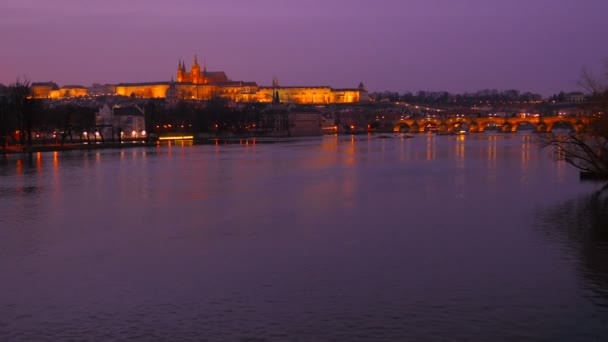 Široký statický záběr na Vltavu a Pražský hrad v soumraku