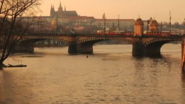 Gün Batımında Prag'da Lejyon Köprüsü'nden Geçen İki Tramvay