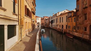 VENICE, İtalya, 7 Kasım 2024 - Venedik, İtalya 'daki ünlü kanallardan birinin çarpıcı görüntüsü, ilginç binalar, güçlü yansımalar ve canlı yeşil su