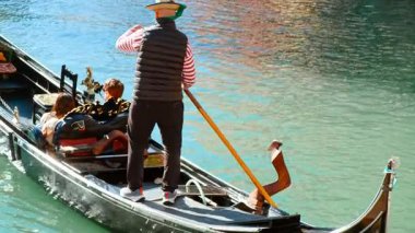 VENICE, İtalya, 7 Kasım 2024 - Bir gondolcu geleneksel mimariyle çevrili Venedik, İtalya 'daki birçok kanaldan birinde gondolunu sakince süzülüyor