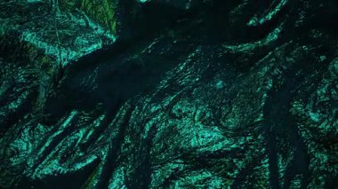 Işıldayan, zümrüt yeşili katları olan bir yüzey. Metalik parlaklık ve karmaşık çıkıntılar lüks, neredeyse diğer dünyalardan gelen bir maddeyi işaret ediyor.