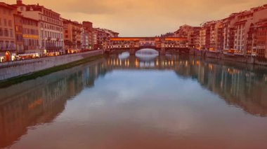 FLORENCE, İtalya, 12 Mart 2024 - Arno Nehri ve Ponte Vecchio 'nun Floransa, Toskana, İtalya' da çekimleri, bankalarının yanında geleneksel dükkanlar da yer alıyor.