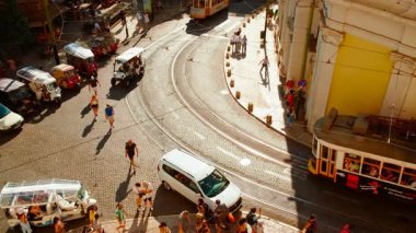 LISBON, Portekiz, 20 HAZİRAN 2023 - Portekiz 'in Alfama ilçesinin dar ve kaldırımlı sokaklarında gün batımında süzülen sarı bir Lizbon tramvayı