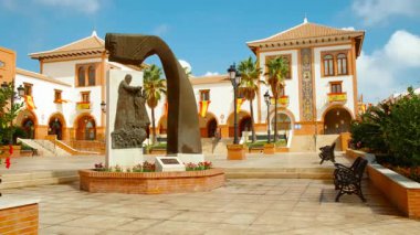 Palos de la Frontera 'daki Plaza de Espana, Huelva, Endülüs, İspanya, İspanyol bayraklarıyla süslenmiş, ulusal gurur ve tarih yayıyor.