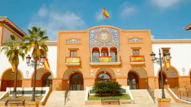 Palos de la Frontera 'daki Plaza de Espana, Huelva, Endülüs, İspanya, İspanyol bayraklarıyla süslenmiş, ulusal gurur ve tarih yayıyor.