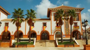 Palos de la Frontera 'daki Plaza de Espana, Huelva, Endülüs, İspanya, İspanyol bayraklarıyla süslenmiş, ulusal gurur ve tarih yayıyor.