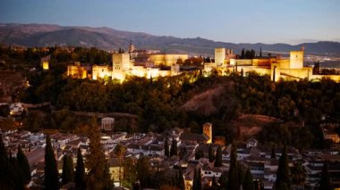 Çekimler Alhambra Sarayı 'nın gece gökyüzüne karşı aydınlatıldığını gösteriyor. Granada, Endülüs, İspanya' nın Eski Mahallesi 'ne bakıyor.
