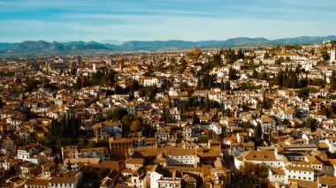 Albaicin (ayrıca Albayzin olarak da bilinir), Granada, Andalucia, İspanya 'nın dörtte biri, günbatımı renkleriyle yıkanır ve evlerin ve selvi ağaçlarının üzerine ışıldar.