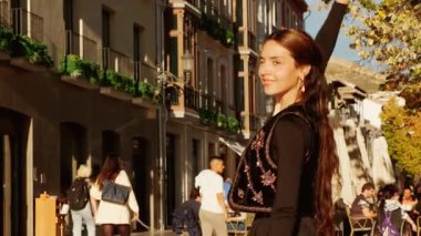 Granada, İspanya, 23 Kasım 2023 - Siyah elbiseli bir Flamenko dansçısı Granada, Endülüs, İspanya sokaklarındaki tutkulu performansıyla büyülendi