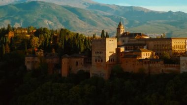 Güneş batarken, Alhambra Sarayı ve Granada, Endülüs, İspanya 'nın Eski Mahallesi sıcak renklerle yıkanarak çarpıcı bir manzara yaratıyor.