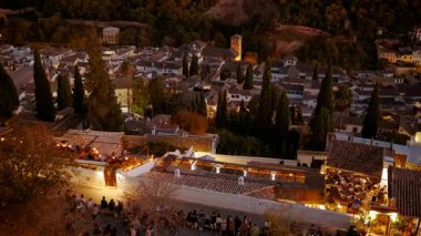 Çekimler Alhambra Sarayı 'nın gece gökyüzüne karşı aydınlatıldığını gösteriyor. Granada, Endülüs, İspanya' nın Eski Mahallesi 'ne bakıyor.