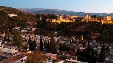 Çekimler Alhambra Sarayı 'nın gece gökyüzüne karşı aydınlatıldığını gösteriyor. Granada, Endülüs, İspanya' nın Eski Mahallesi 'ne bakıyor.