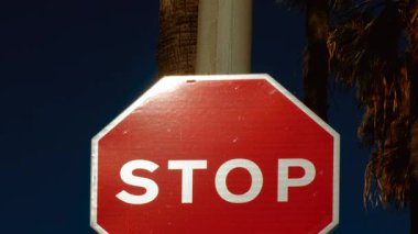 Koyu mavi arkaplana karşı yansıtıcı yüzeyi olan standart kırmızı DUR işareti