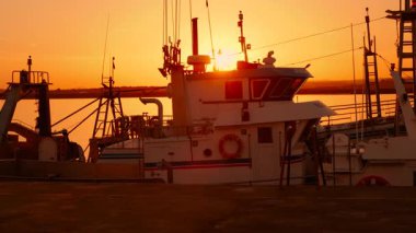 AYAMONTE, Huelva, İspanya, 20 ECTOBER 2023 - Ayamonte, Huelva, Endülüs, İspanya 'da demirli balıkçı tekneleri, günbatımının arka planda Guadiana Nehri üzerinde altın bir parıltı oluşturması