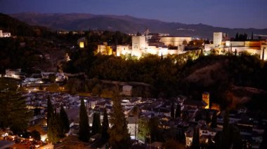 Çekimler Alhambra Sarayı 'nın gece gökyüzüne karşı aydınlatıldığını gösteriyor. Granada, Endülüs, İspanya' nın Eski Mahallesi 'ne bakıyor.