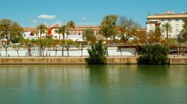 SEVILLE, circa 2023 - Guadalquivir nehri ve Seville, Endülüs, İspanya, Torre del Oro, şehrin ikonik altın kulesi, ve çarpıcı manzaralı nehir yürüyüşü