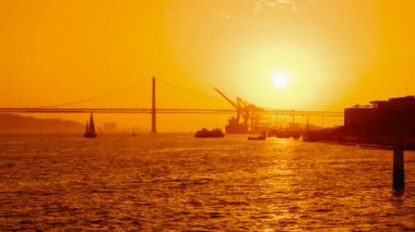 Tagus, Ponte 25 de Abril asma köprüsü ve Lizbon, Portekiz 'deki Cristo Rei mabedi üzerinde inanılmaz bir gün batımı.