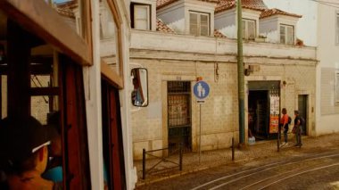 LISBON, takriben 2022 - Lizbon, Portekiz 'in Alfama ilçesinin pitoresk caddeleri boyunca 28 numaralı ikonik tramvayda seyahat
