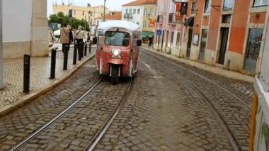 LISBON, takriben 2022 - Lizbon, Portekiz 'in Alfama ilçesinin pitoresk caddeleri boyunca 28 numaralı ikonik tramvayda seyahat