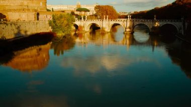 Nefes kesici bir günbatımı Castel Sant 'Angelo, Ponte Sant' Angelo köprüsü ve Roma, İtalya 'daki dolambaçlı Tiber nehri aydınlatır.